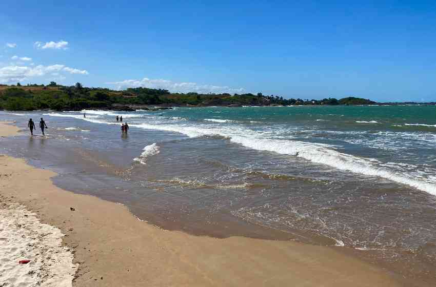 Faixa de areia e mar com ondas suaves na Praia da Cerca, em Guarapari