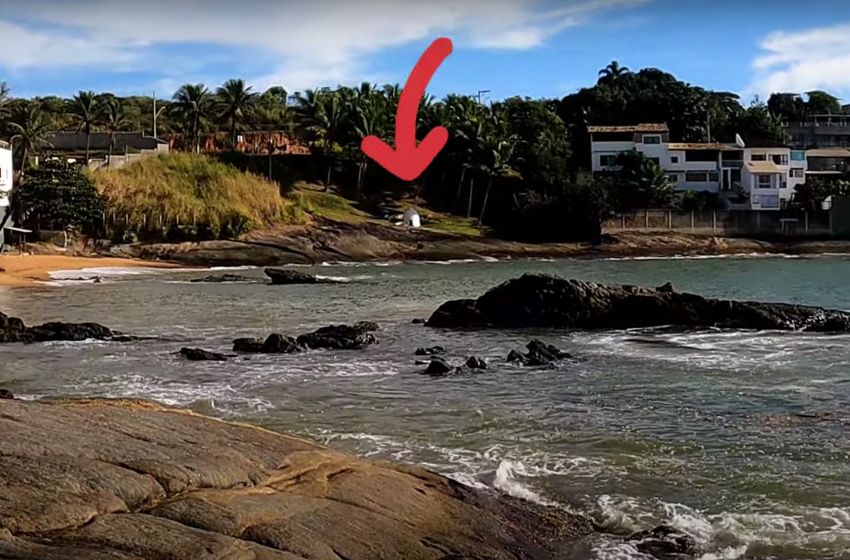 Pedras &agrave; beira-mar perto da Praia do Valad&atilde;o, com seta indicando o local do Po&ccedil;o dos Jesu&iacute;tas, em Guarapari