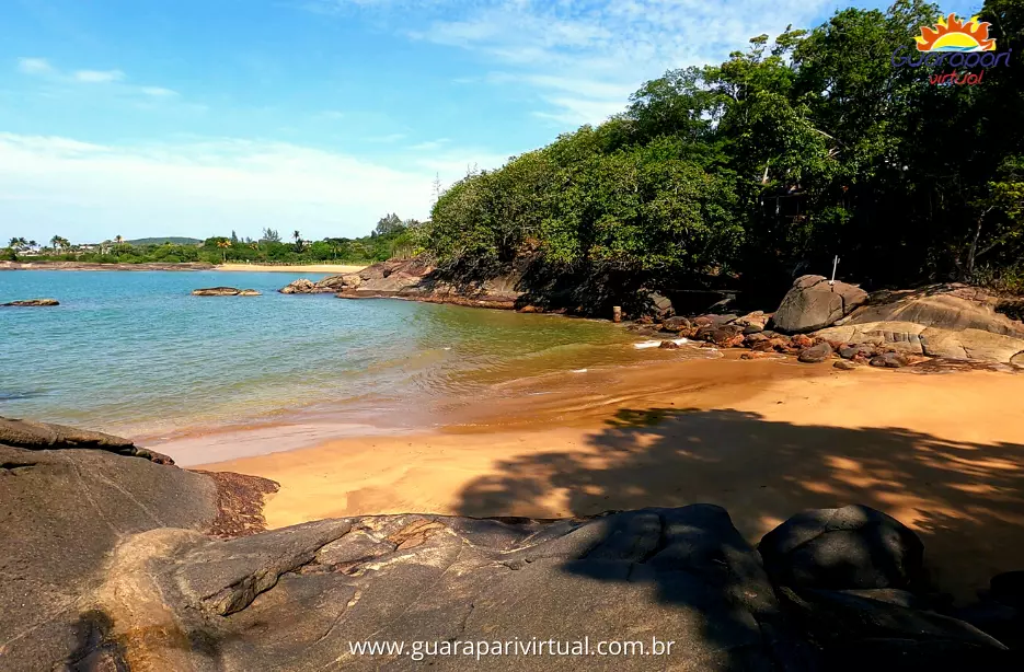 Praia do Morcego, em Guarapari: pequena enseada de areia dourada e &aacute;gua calma e transparente, cercada por pedras e mata