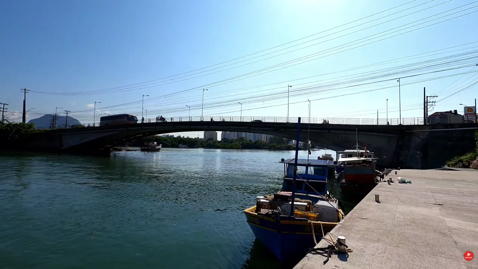 Ponte sobre a ba&iacute;a de Guarapari vista do cais, com barcos de pesca atracados