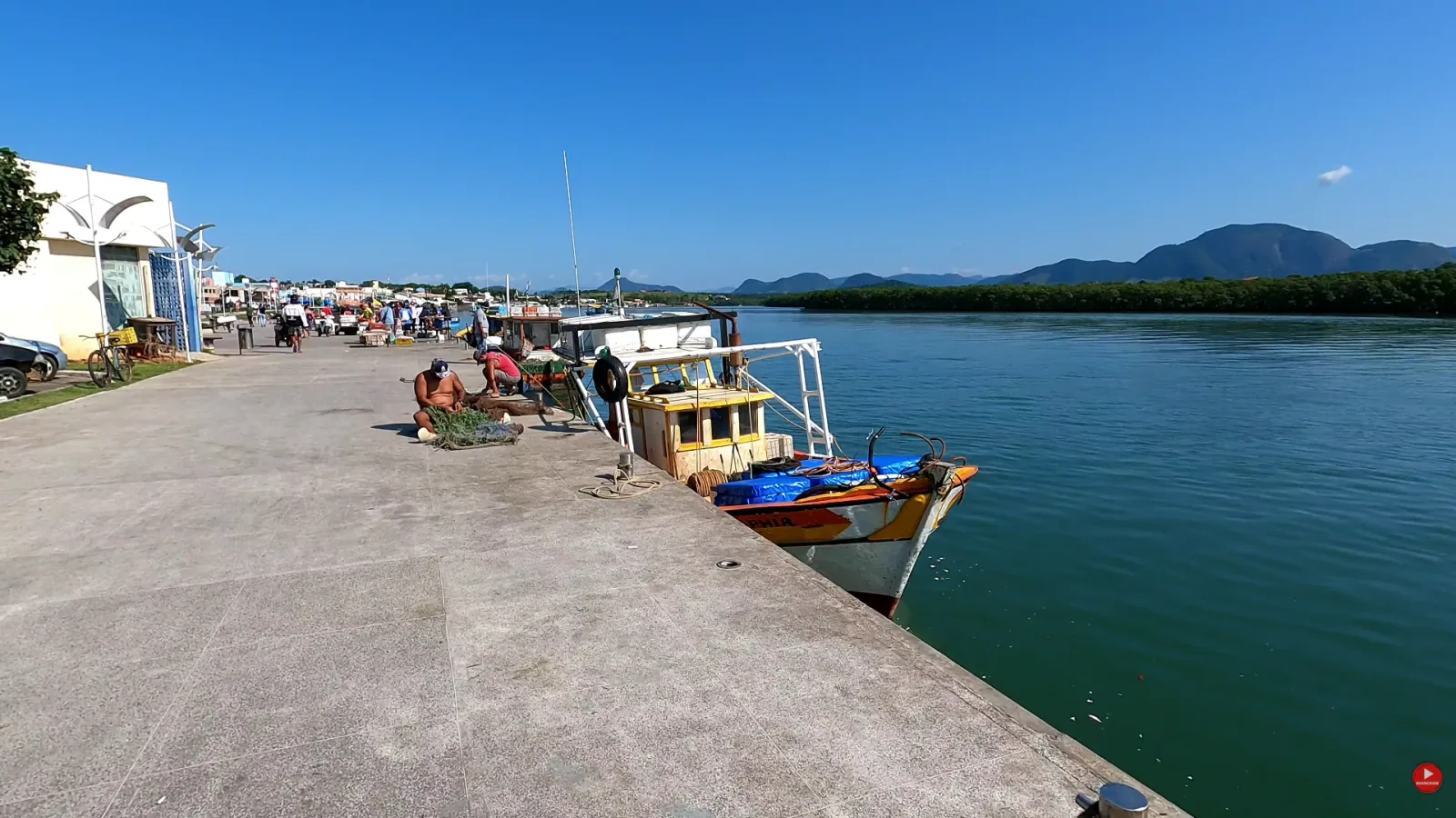 Cal&ccedil;ad&atilde;o do Cais de Guarapari com barcos de pesca atracados e o manguezal na outra margem