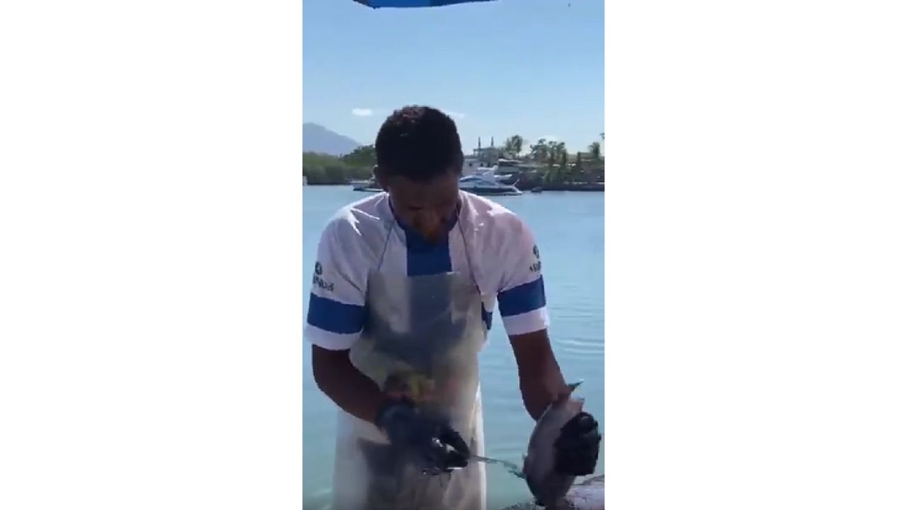 Peixeiro limpando pero&aacute; no cais do Centro de Guarapari