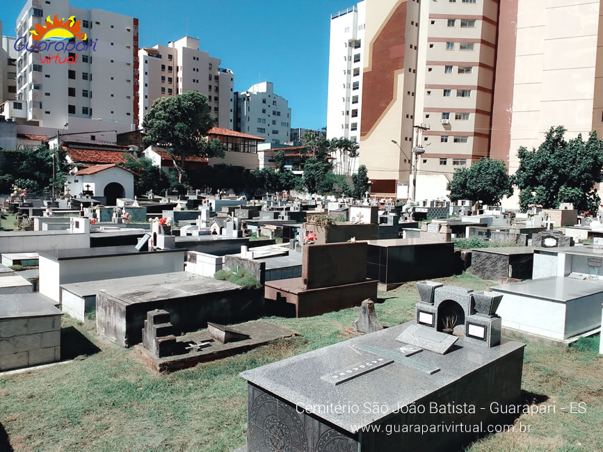 T&uacute;mulos do Cemit&eacute;rio S&atilde;o Jo&atilde;o Batista, no Centro de Guarapari, com pr&eacute;dios ao fundo