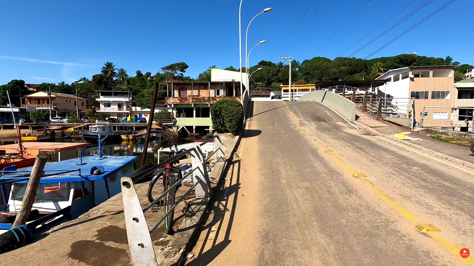 Ponte de acesso ao centrinho da Aldeia de Peroc&atilde;o, com barcos de pesca ancorados ao lado, em Guarapari