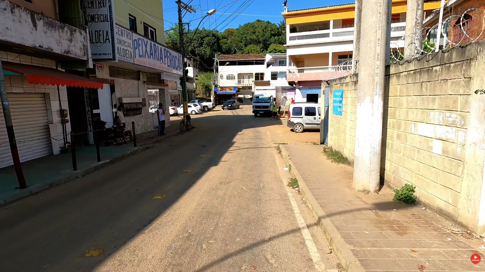 Rua logo depois da ponte, com a Peixaria Peroc&atilde;o e o Centro Comercial Aldeia, em Guarapari