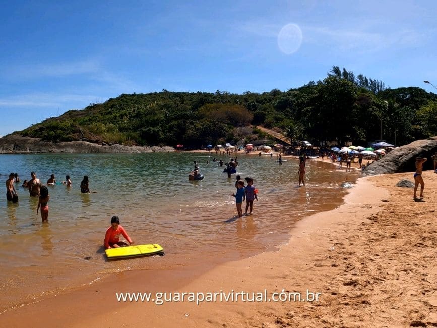 Crian&ccedil;as brincando na &aacute;gua rasa e calma da Praia de Una, em Guarapari