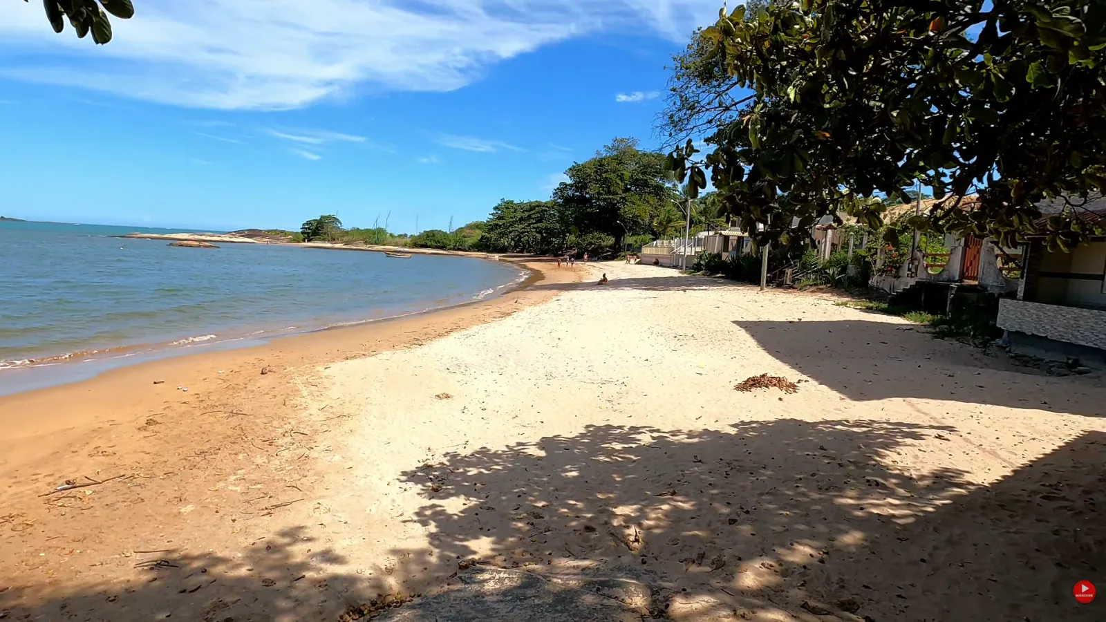 Faixa de areia da Praia do Boi&atilde;o com &aacute;rvores e casas na beira, em Guarapari